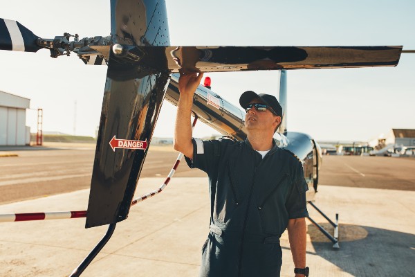 male-pilot-examining-helicopter-tail-wing-PFWYVWQ (1)